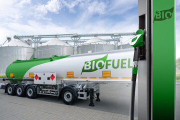 Wall Mural - Fuel nozzle with inscription BIO on a background of tank trailer with biofuel. Carbon neutral bio fuel decarbonization concept