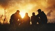 © tinnakorn - Silhouettes of four friends enjoying the sunset on a mountaintop, creating a sense of camaraderie and adventure.