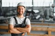 © Serhii - Portrait of a young worker in a hard hat at a large metalworking factory. Shiftman on the warehouse of finished products