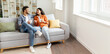 © Home-stock - Happy indian couple relaxing and drinking coffee, sitting on couch at home, talking , free space