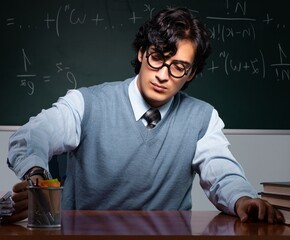 Wall Mural - Young math teacher in front of chalkboard