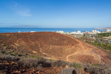 Panorama of volcano Montana Chayofita, holiday resort Playa de las Americas with hotels and Atlantic Ocean on Canary Island Tenerife, Spain