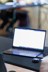 Open laptop on a conference table in an empty meeting room