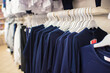© Ruslan Russland - dark blue school uniforms on hangers in a store