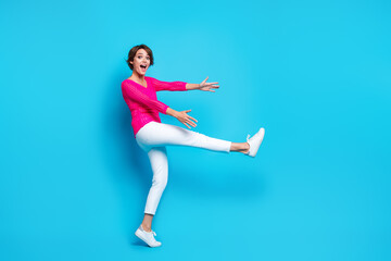 Wall Mural - Full length photo of funky cheerful lady dressed pink knitted shirt dancing catching arms empty space isolated blue color background