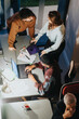 © qunica.com - Overhead view of a multiracial team in discussion during a business meeting, with laptops, notes, and a casual work environment.