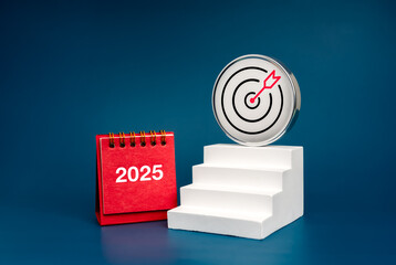 Wall Mural - New year business goal, financial and technology concept. 3d chrome Target icon on highest step white stair as growth graph steps near 2025 desk calendar isolated on blue background, minimal style.