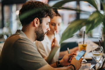 Wall Mural - Businesspeople meeting at a coffee bar, engaging in discussions using mobile phones and notes, creating a collaborative environment.