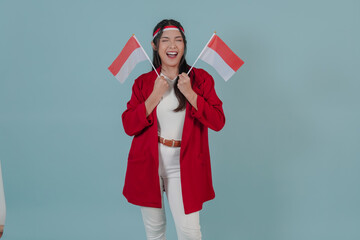 Excited Indonesian woman raising two flags with a happy successful expression.