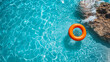 © Synthesia Studio - Minimal summer banner with bright orange lifebuoy floating in clear blue water near rocky shore