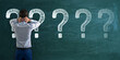 © Who is Danny - Back view of stressed young european businessman with chalk drawn question marks on blackboard background. Solution, education and knowledge concept.