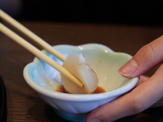 Wall Mural - 日本の和食レストランで新鮮なホタテを食べる子供の様子