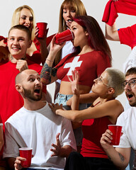 Wall Mural - Group of young people, men and women dresses in country flag colors, supporting favorite team during soccer game. Concept of sport, emotions, tournament, competition, event