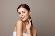 © SHOTPRIME STUDIO - Beautiful young woman posing with hands on face, looking at camera on gray background
