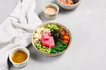 Wall Mural - Tuna Poke Bowl with Edamame, Avocado, and Cherry Tomatoes on a Light Gray Background