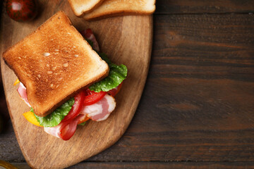 Wall Mural - Tasty sandwiches with bacon and tomato on wooden table, top view. Space for text