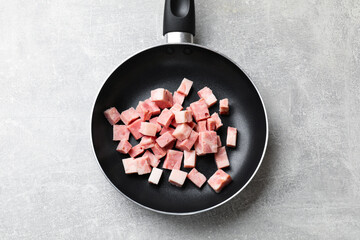 Wall Mural - Pieces of fresh bacon in frying pan on grey textured table, top view