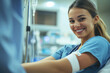 © Miquel - A nurse in a blue uniform smiles at the camera