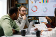 © YURII MASLAK - A team of young mixed race businessmen working on a startup. Business strategy, teamwork. Discussion and generation of ideas. Communication network. multinational professional team.