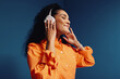 © Jacob Lund - Woman enjoying music with headphones in vibrant orange and blue colorblock studio space