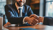 © Shutter2U - Two businessmen shaking hands in a meeting, signifying a successful agreement.