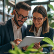 © muhammadarslan - A business man and woman smiling at an iPad, Business people looking at tablet, business people working together in a cafe, business people working on laptop, business people working together