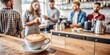 © hobonski - A warm and inviting coffee shop scene featuring a beautifully crafted latte in the foreground as baristas and customers engage in friendly conversations in the background.
