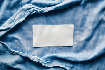 Blank White Laundry Care Label on Blue Shirt Fabric Texture