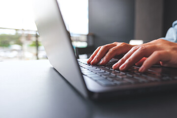 Wall Mural - closeup image of a woman hands working and typing on laptop computer keyboard