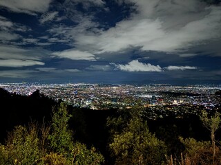 Ciudad en la noche con nubes blancas y cielo azul divino