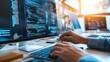 © Alice a. - A person is typing on a computer keyboard in front of a monitor displaying blue code. Concept of focus and concentration as the person works on their computer. The blue color of the monitor