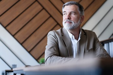 Poster - Smiling mature business man executive wearing shirt sitting at desk using laptop. Happy busy professional middle aged manager investor working on computer looking away in office