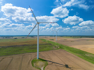 Drone view Windmills wind turbines farm power generators landscape blue sky in beautiful nature landscape for production of renewable green energy. Eco friendly. Poland, Europe, aerial photography