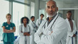 © VK Studio - Surrounded by colleagues, a confident doctor stands front and center in a hospital setting, conveying leadership, expertise, and teamwork in the medical field.