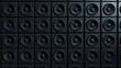 © sornram - A wall of black speakers arranged in a grid, perfect for showcasing music production, sound design, or audio technology themes.