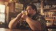 © Bonsales - Man enjoying a cold beer in cozy pub, relaxed atmosphere with warm lighting, beer concept
