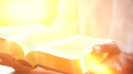 Wall Mural - Closeup of Man Holding Glowing Holy Bible on Wooden Table - Male Christian Studying and Reading God's Word for Salvation and Forgiveness of Sins, Religious Belief, Jesus Gospel