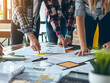 © Lotti - Interior design team collaborating on color scheme and furniture layout for modern office space.