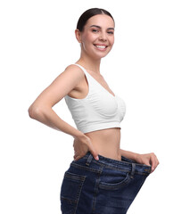 Poster - Diet and weight loss concept. Happy young woman in big jeans showing her slim body on white background