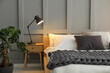 © New Africa - Stylish bedroom interior with comfortable bed, lamps and houseplant
