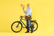 © New Africa - Postman with bicycle delivering letters on yellow background
