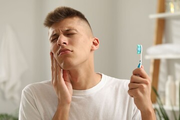 Poster - Young man with toothbrush suffering from toothache in bathroom