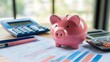 © sa-photo - Piggy bank on a desk with financial documents and a calculator