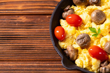 Canvas Print - Healthy vegetarian breakfast . Scrambled eggs in pan with cherry tomatoes and parsley