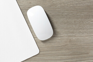 Wall Mural - Wireless mouse and mousepad on wooden table, top view. Space for text