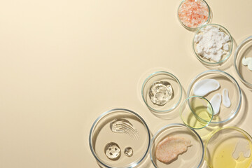 Wall Mural - Petri dishes with different cosmetic products on beige background, flat lay. Space for text