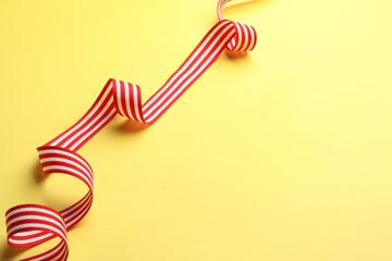 Wall Mural - Striped ribbon on yellow background. Space for text