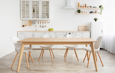 Wall Mural - Scandinavian classic white kitchen with wooden details, minimalistic interior design. Modern furniture with accessories and various utensils, table and chairs in dinning room, copy space