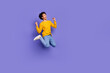 © deagreez - Photo of joyful cheerful funny man wear trendy yellow clothes look empty space isolated on purple color background