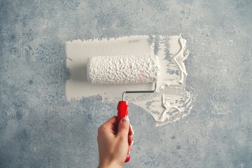 Canvas Print - A person applying a coat of paint to a wall using a roller